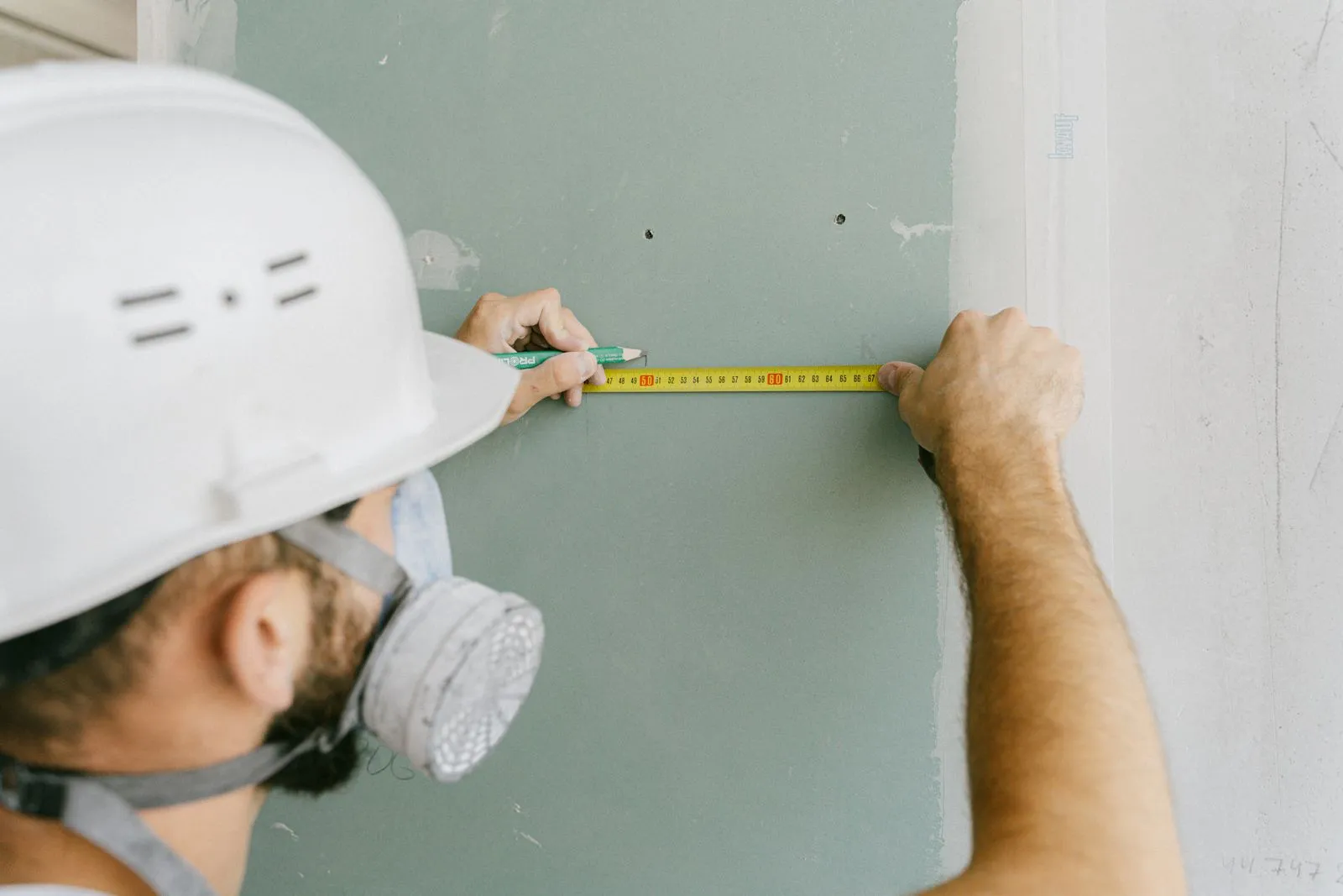 Technician cutting out a section of damaged drywall
