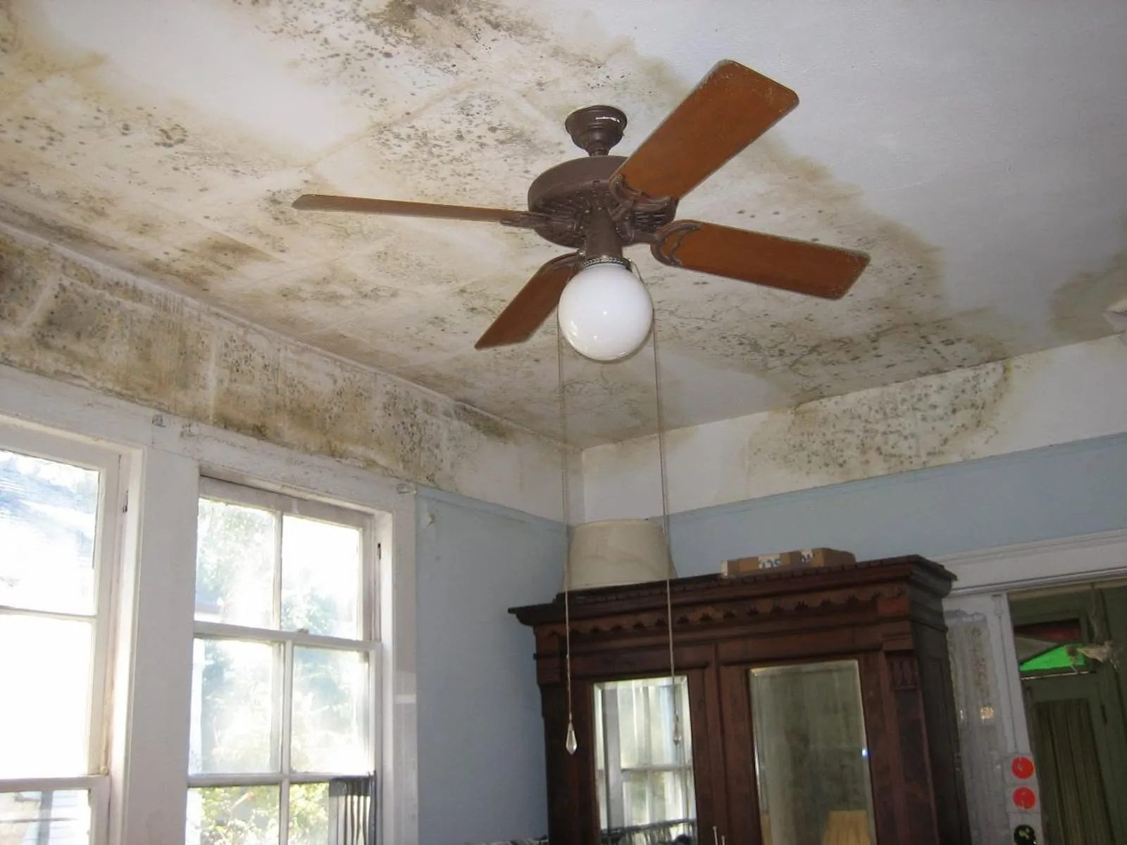 Ceiling with dark staining spreading out from a bathroom exhaust fan